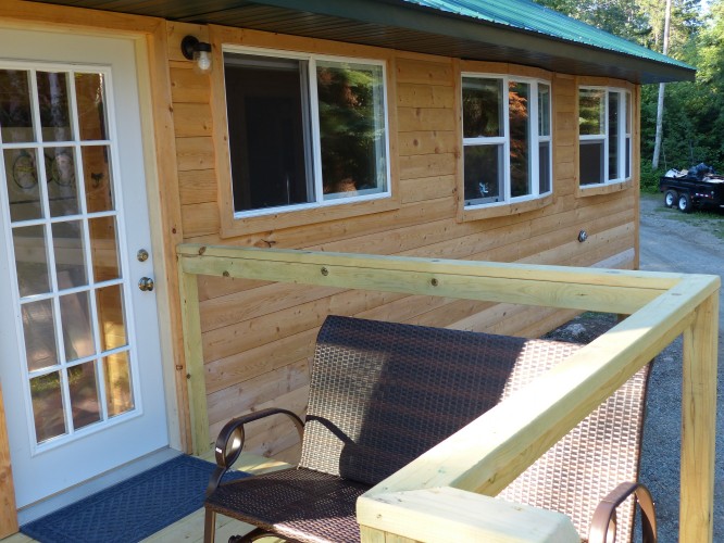 Front of the cabin provides windows, deck, and glider to enjoy the view.